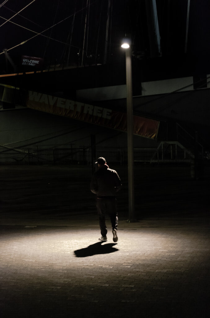 man walking under spotlight